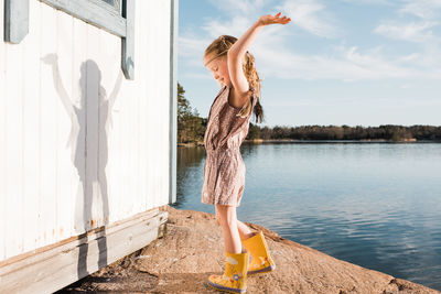 Girl dancing using her imagination playing dress up at the beach