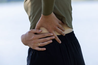 Midsection of woman standing against clear sky