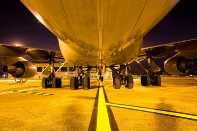 Airplane at airport runway against sky at night