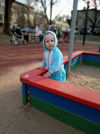 Portrait of cute baby girl playing in playground