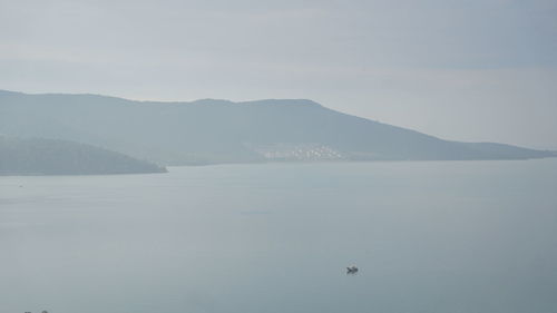 Scenic view of sea and mountains against sky