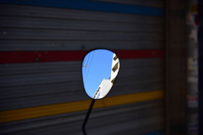 Close-up of road sign against wall