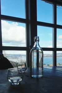 Close-up of glass bottle on table against window