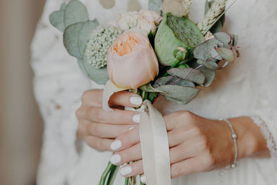 Midsection of woman holding flower bouquet