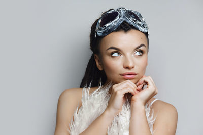 Portrait of young woman against white background