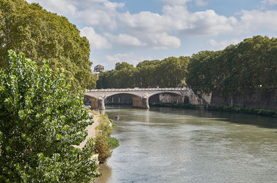 Arch bridge over river against sky