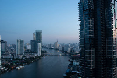 Top view cityscape of bangkok at chao phraya river in morning blue sky