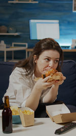 Smiling woman eating pizza at home