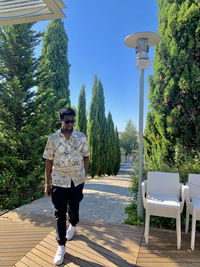 Full length of young man standing on footpath