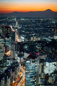 High angle view of illuminated cityscape against sky during sunset