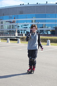 Teenage girl inline skating at parking lot in city