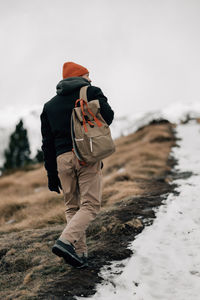 Rear view of man standing on snow