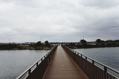 Pier over river against sky
