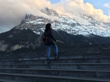 Full length of girl standing on steps by snowcapped mountains