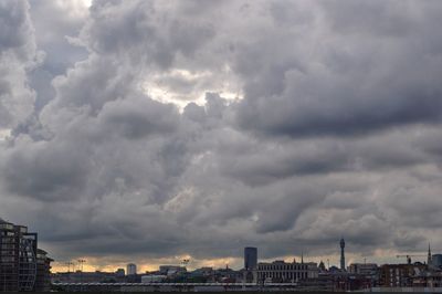 Buildings in city against cloudy sky