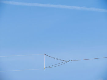 Low angle view of power lines against blue sky