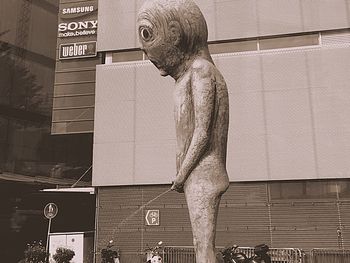 Statue of woman with arms raised in city