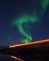 Light trails on road against sky at night