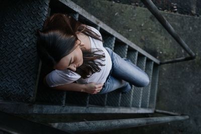 High angle view of woman sitting on staircase