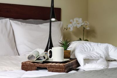 Table and coffee cup on bed at home