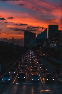 High angle view of cars on street during traffic in city at sunset