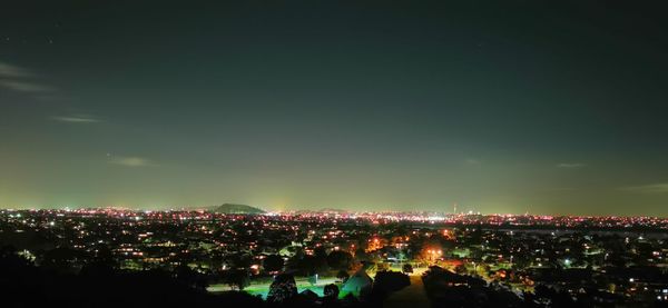 High angle view of illuminated cityscape against sky at night