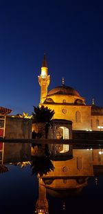 Illuminated building against clear sky at night