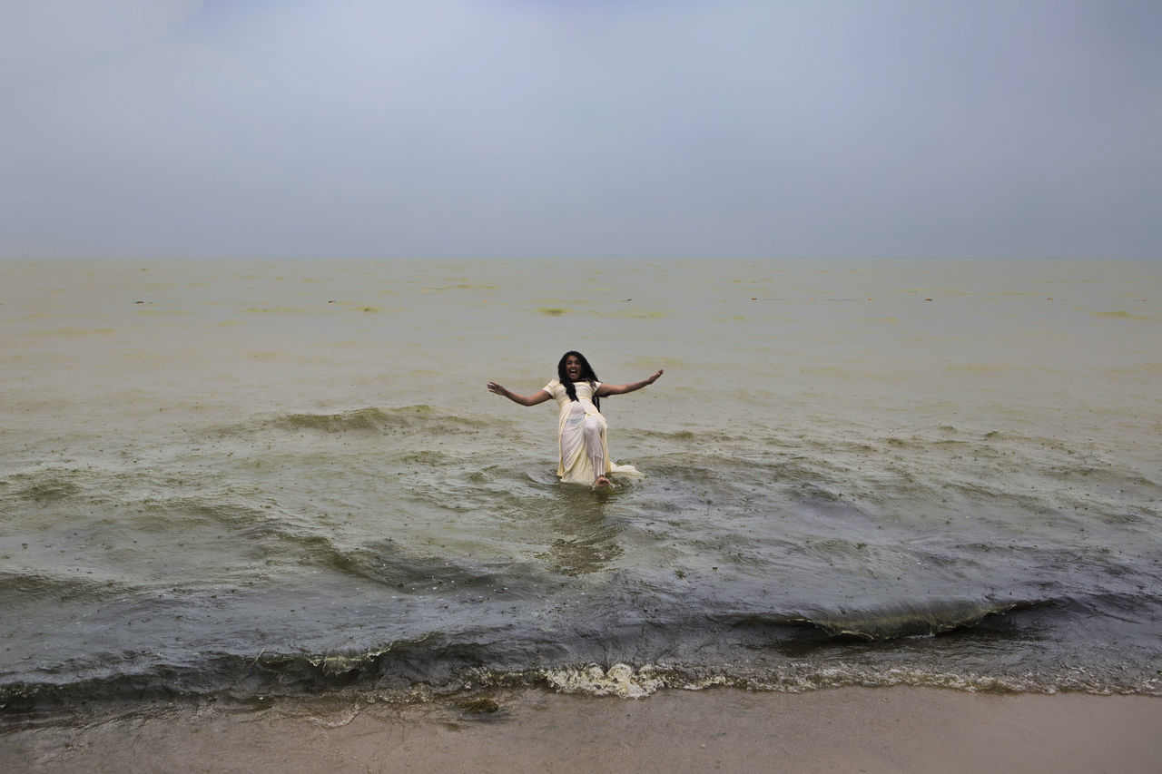Jumping in the sea in wedding dress 