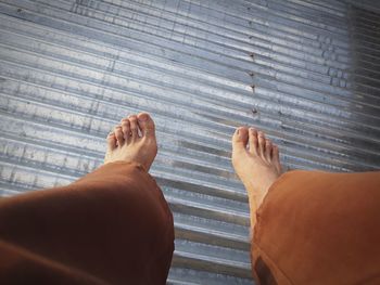 Low section of man standing on wooden floor