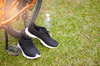 High angle view of shoes and bottle by grassy field