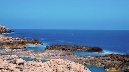 Scenic view of sea against clear blue sky