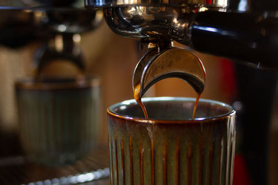 Close-up of coffee pouring in glass