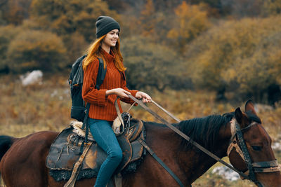 Young woman riding horse