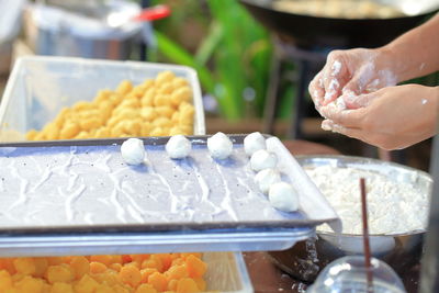 Person preparing food at market stall