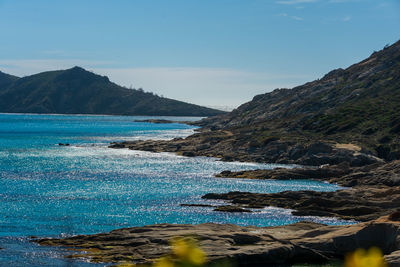 Scenic view of sea and mountains against sky