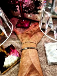 Close-up high angle view of hand holding glass on table