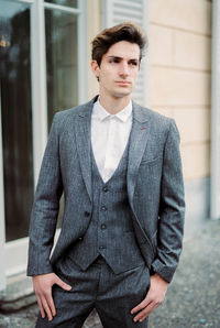 Portrait of businessman standing against wall