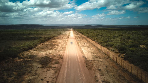 Panoramic shot of road amidst land against sky