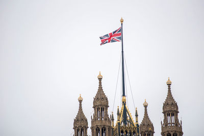 Low angle view of flags on building against sky