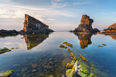 Scenic view of rock formation in sea against sky