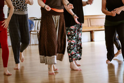 Low section of people standing on hardwood floor