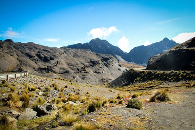 Panoramic view of landscape and mountains against blue sky