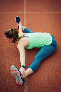 High angle view of young woman exercising on sports track