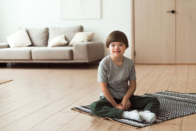 Child down syndrome sitting on floor at home