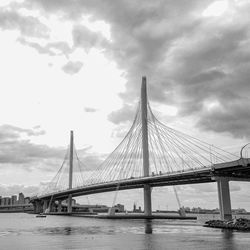 Bridge over river against cloudy sky