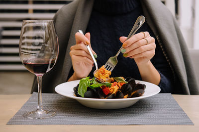 Midsection of woman having food on table