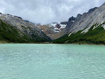 Scenic view of lake by mountains against sky