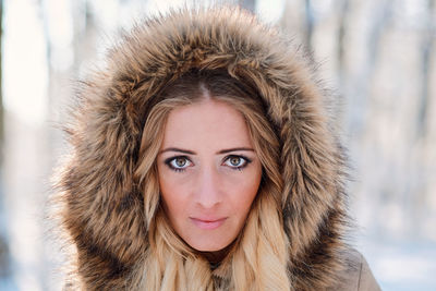 Portrait of young woman wearing warm clothing standing in forest