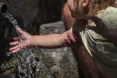 Close-up of cute girl cleaning hands in running water