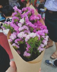 Low section of woman holding flowers